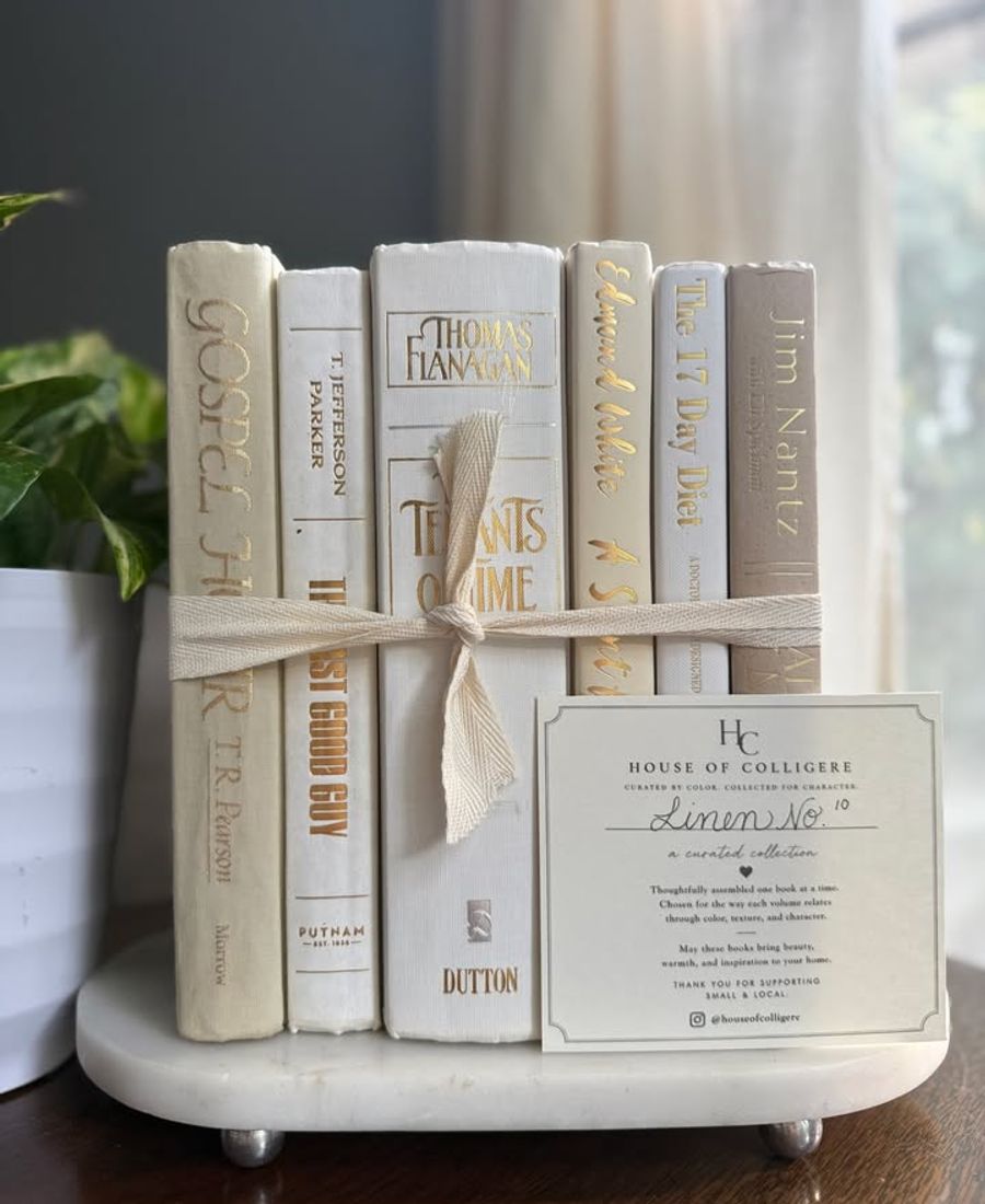 Curated collection of crisp white, ivory, and warm cream books with soft neutral tones.