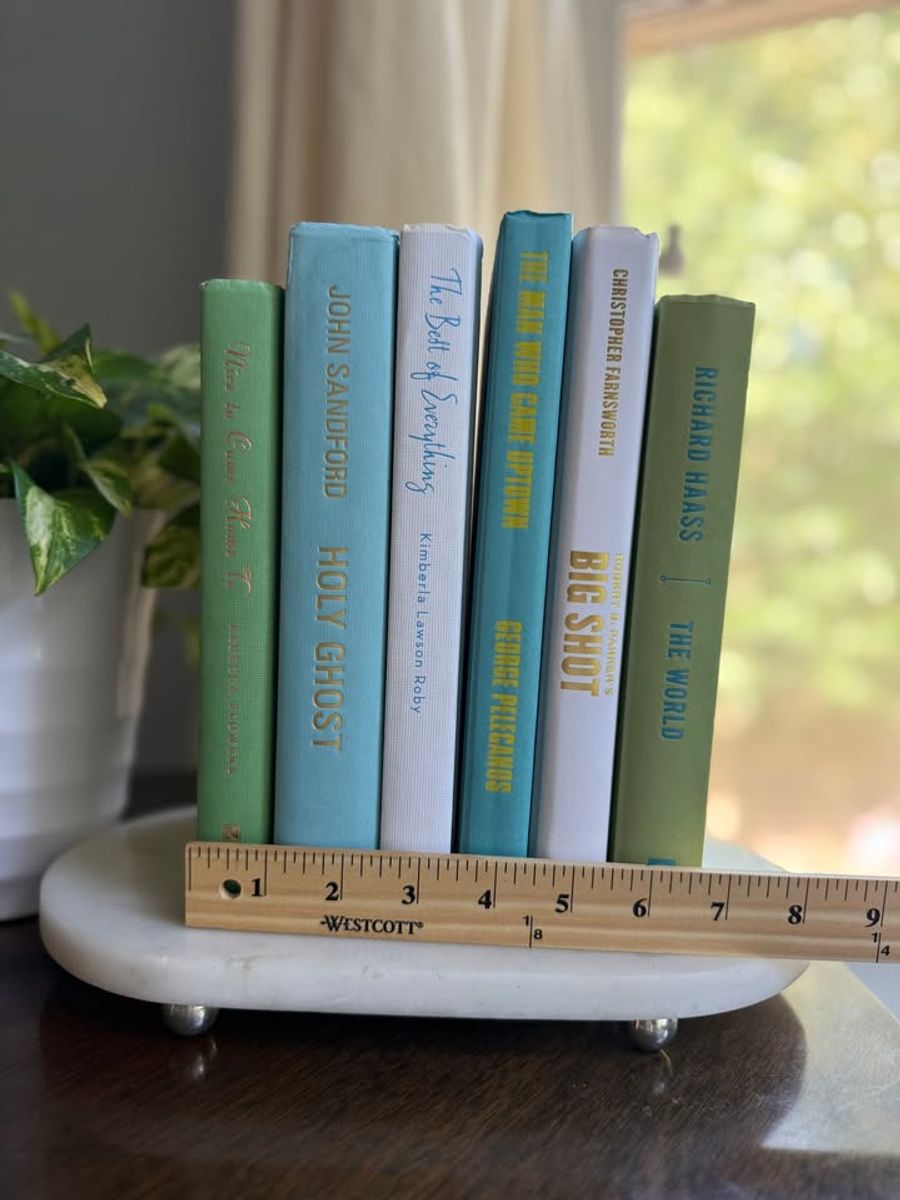 Modernist Edit No. 11 decorative book collection in fresh green, aqua, teal, ivory, and olive tones, tied with neutral linen ribbon and styled on a marble table.
