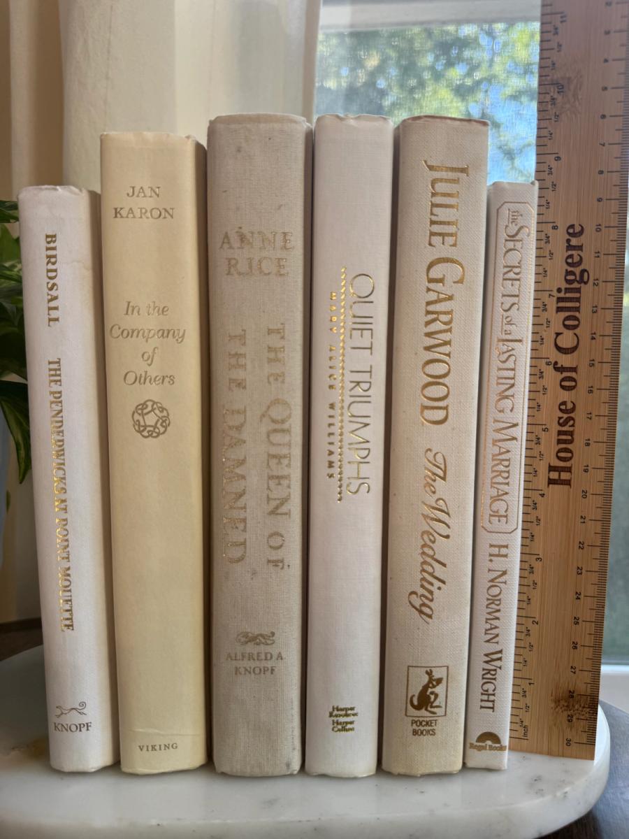 Curated collection of crisp white, ivory, and warm cream books with soft neutral tones.