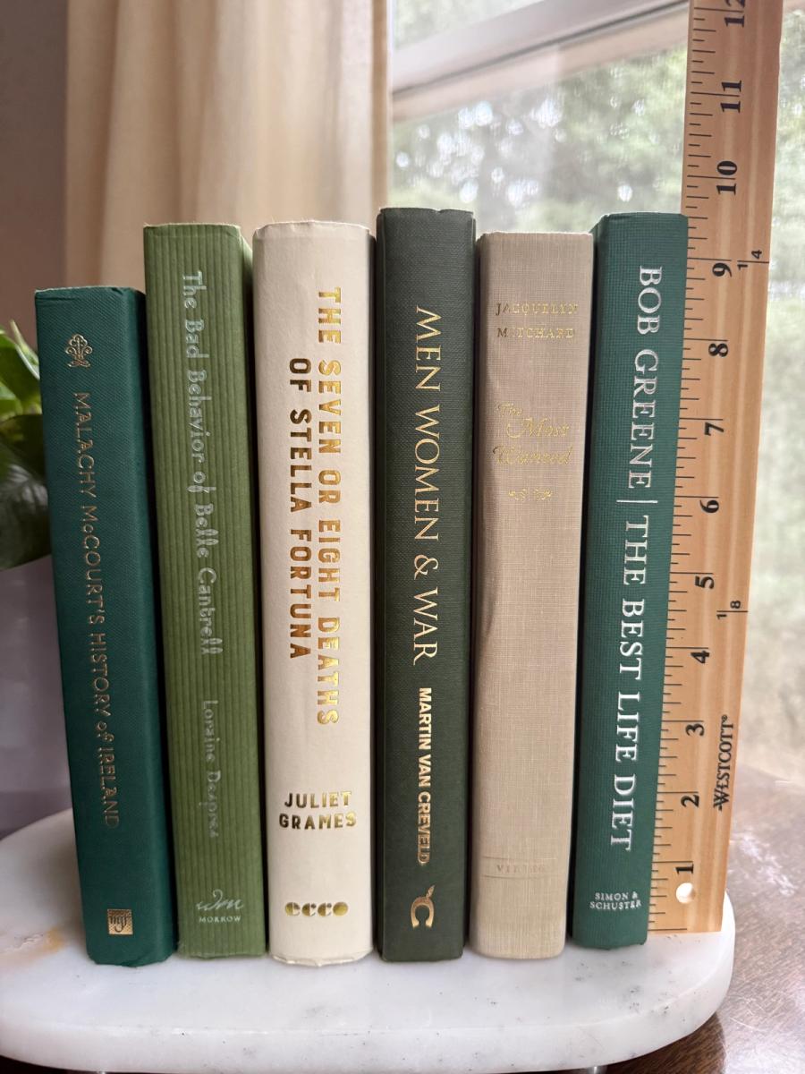 Curated collection of soft sage, olive, cream, and muted green books with botanical tones.