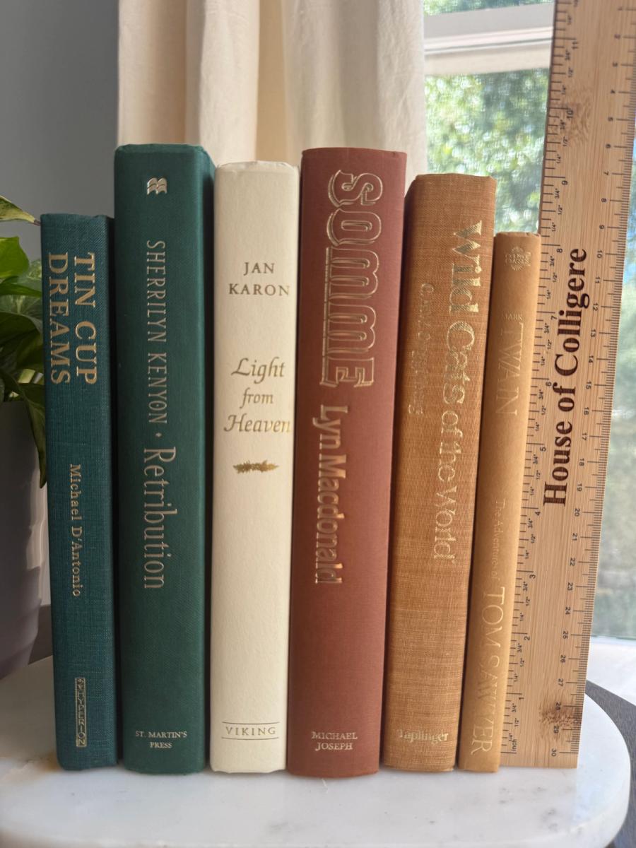 Curated collection of rich brown, hunter green, deep navy, and warm ivory books with classic gold accents.