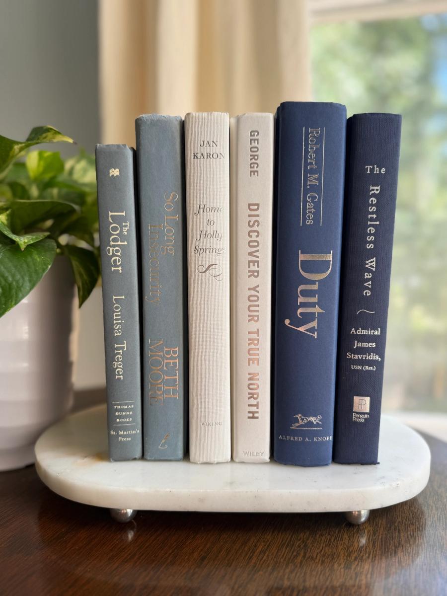 Curated collection of layered blue books ranging from pale coastal blue to deeper ocean tones.