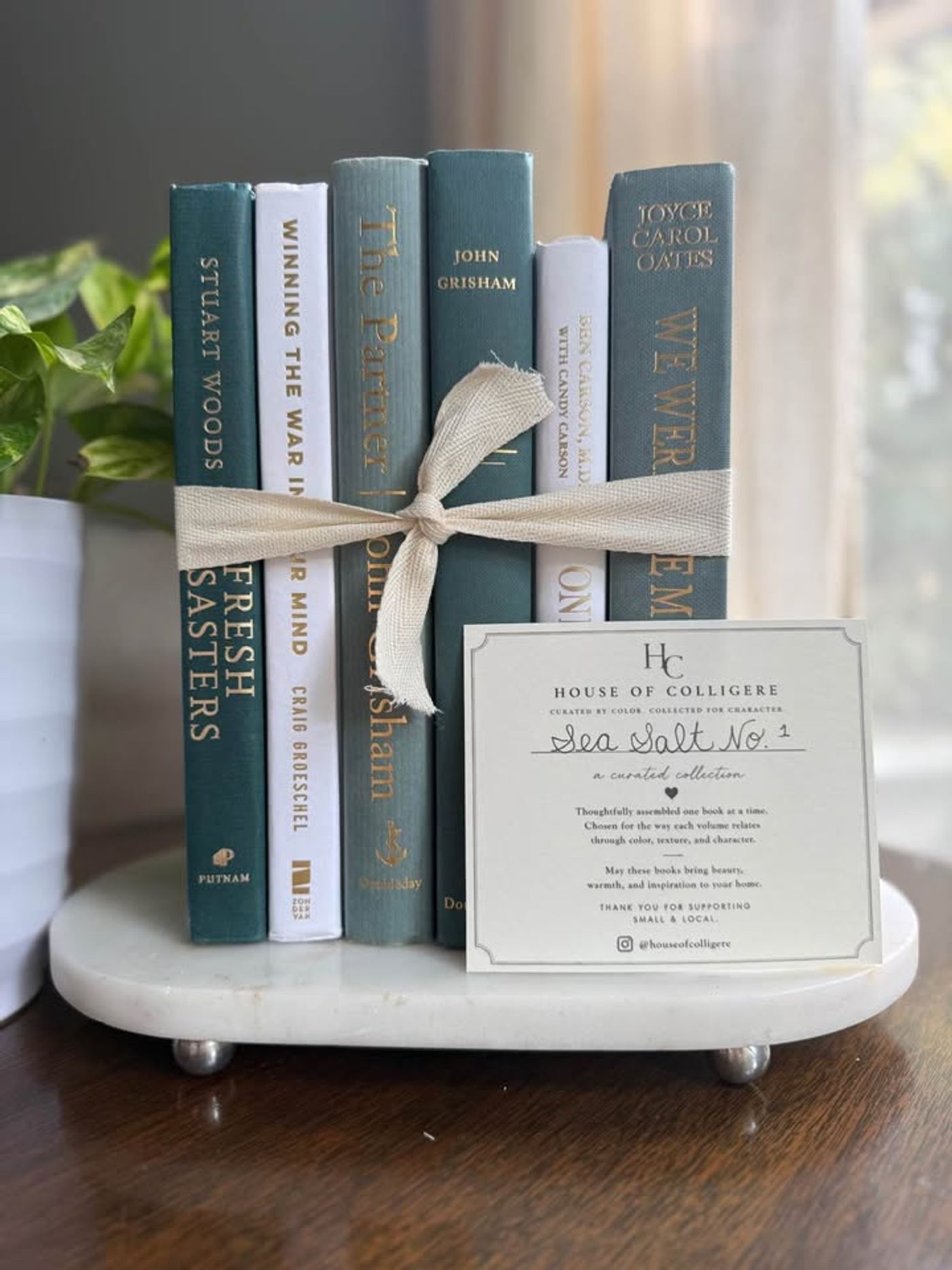 Curated collection of white, pale blue, sand, and soft coastal-neutral books with an airy, sun-faded look.