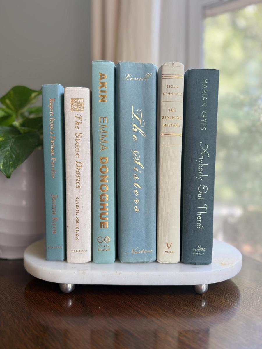 Curated collection of white, pale blue, sand, and soft coastal-neutral books with an airy, sun-faded look.