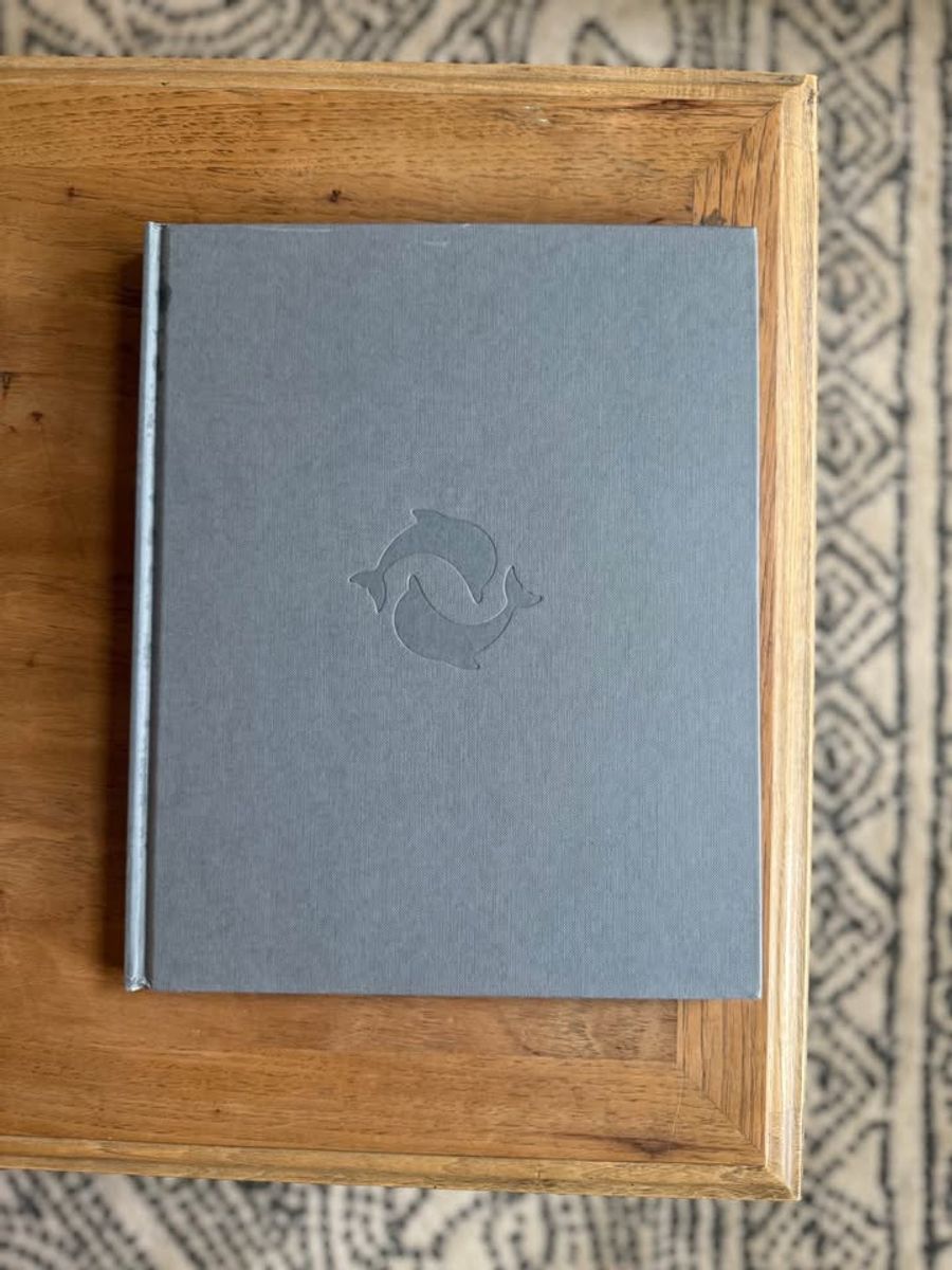 Cream, ivory, warm flax, beige, muted blue-gray, soft taupe undertones, linen-like cloth covers, matte woven texture, subtle gold and metallic lettering, understated traditional styling