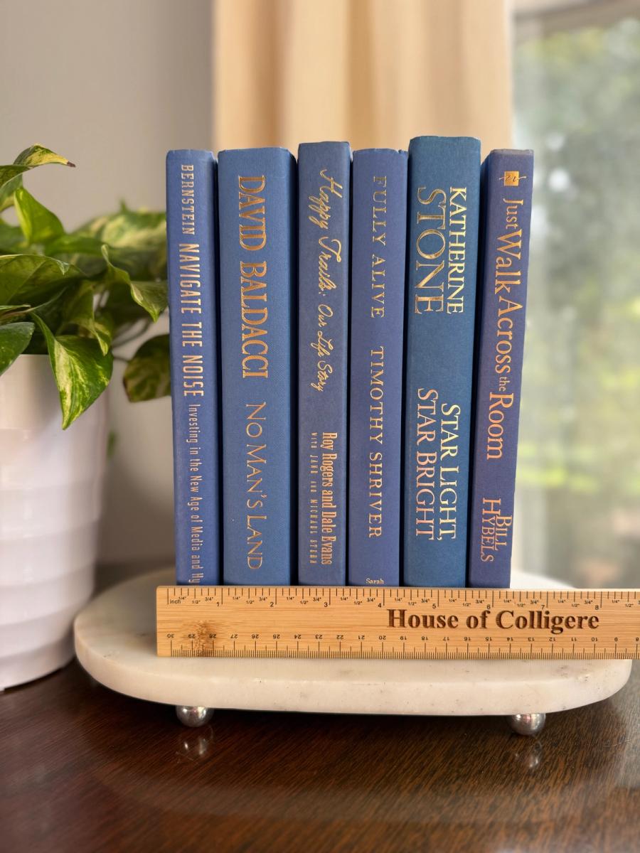 Curated collection of deep navy, warm ivory, brown, and gold-accented books with classic traditional character.