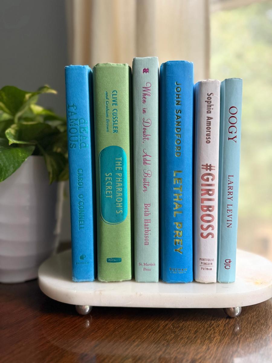 Curated collection of six hardcover books in cobalt blue, sage green, pale aqua, and soft white, tied with natural cotton ribbon and styled beside a House of Colligere collection card.
