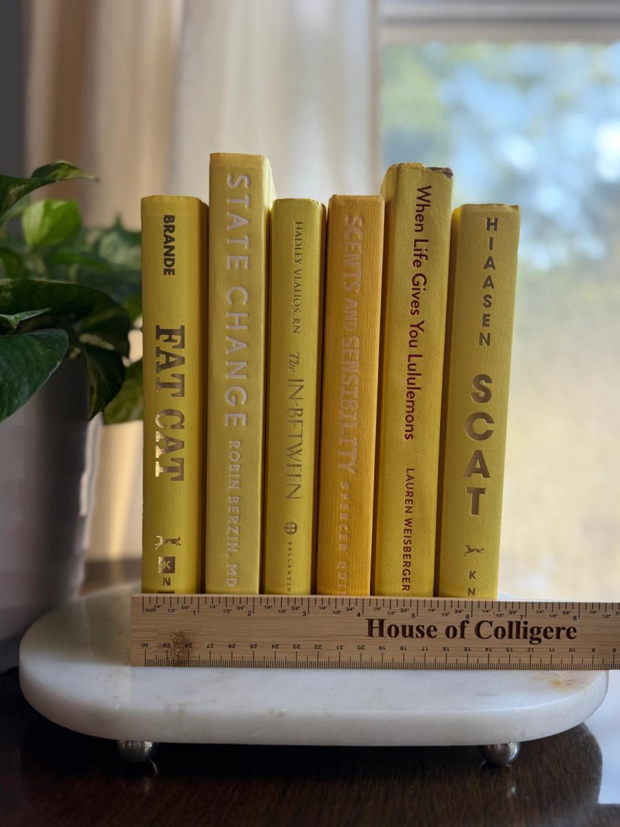 Curated collection of six mustard and golden yellow hardcover books tied with natural cotton ribbon, styled on a marble tray with a House of Colligere Modernist Edit No. 4 collection card.