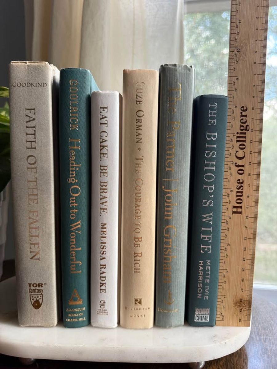 Curated collection of white, pale blue, sand, and soft coastal-neutral books with an airy, sun-faded look.