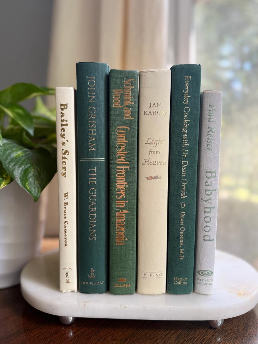 Curated collection of soft sage, olive, cream, and muted green books with botanical tones.