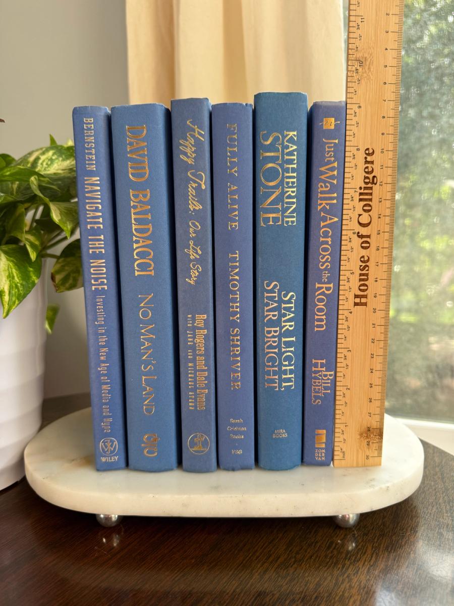 Curated collection of deep navy, warm ivory, brown, and gold-accented books with classic traditional character.