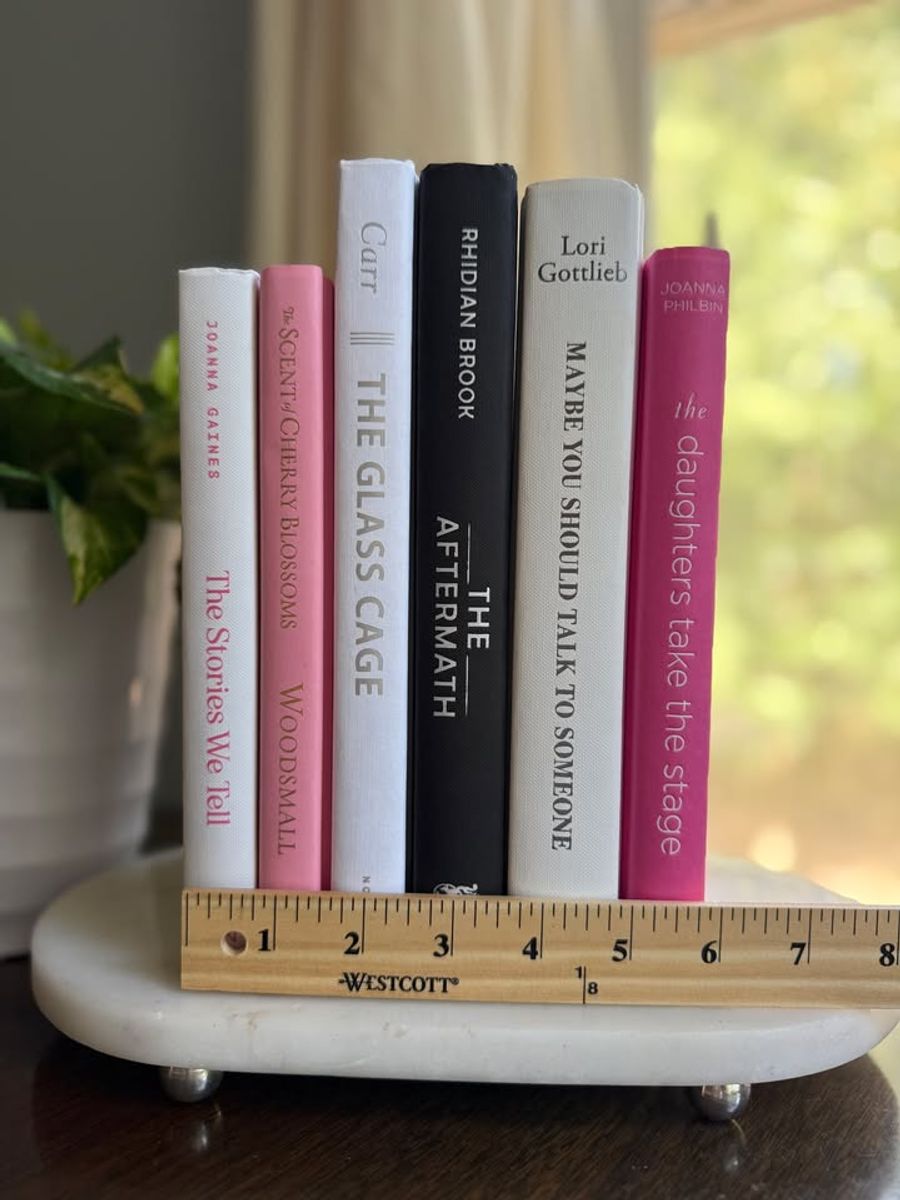 Modernist Edit No. 10 decorative book collection in white, blush pink, black, and raspberry tones, tied with neutral linen ribbon and styled on a marble table.