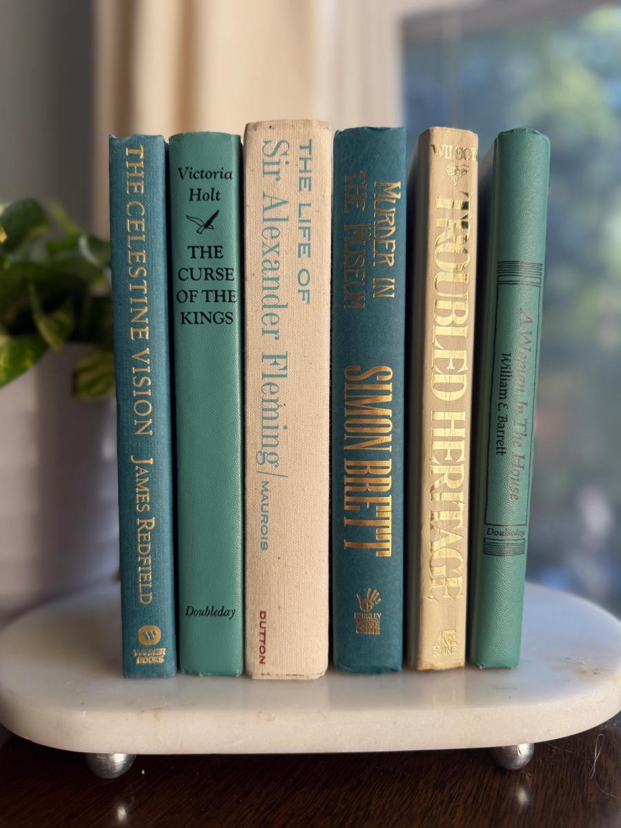 Curated collection of white, pale blue, sand, and soft coastal-neutral books with an airy, sun-faded look.