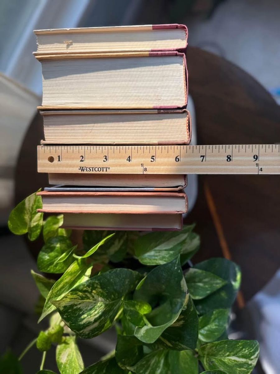Curated collection of dusty rose, plum, warm brown, taupe, and muted berry-toned books with soft vintage character.