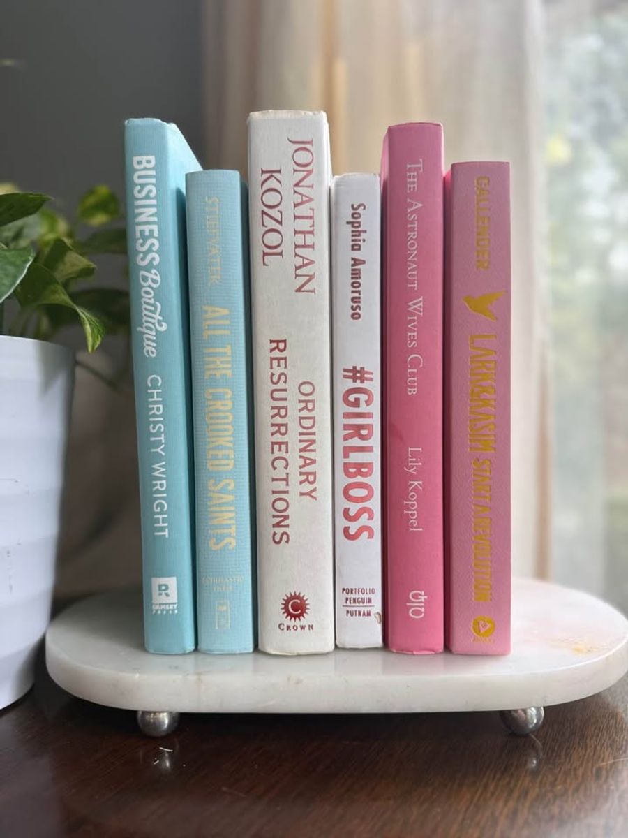 Curated collection of aqua, pale blue, white, and pink books with bright pastel tones and playful contrast.