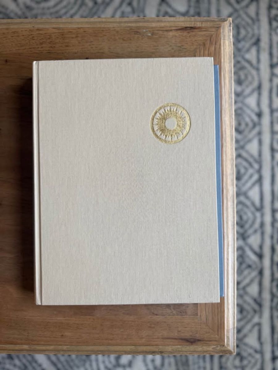 Cream, ivory, warm flax, beige, muted blue-gray, soft taupe undertones, linen-like cloth covers, matte woven texture, subtle gold and metallic lettering, understated traditional styling