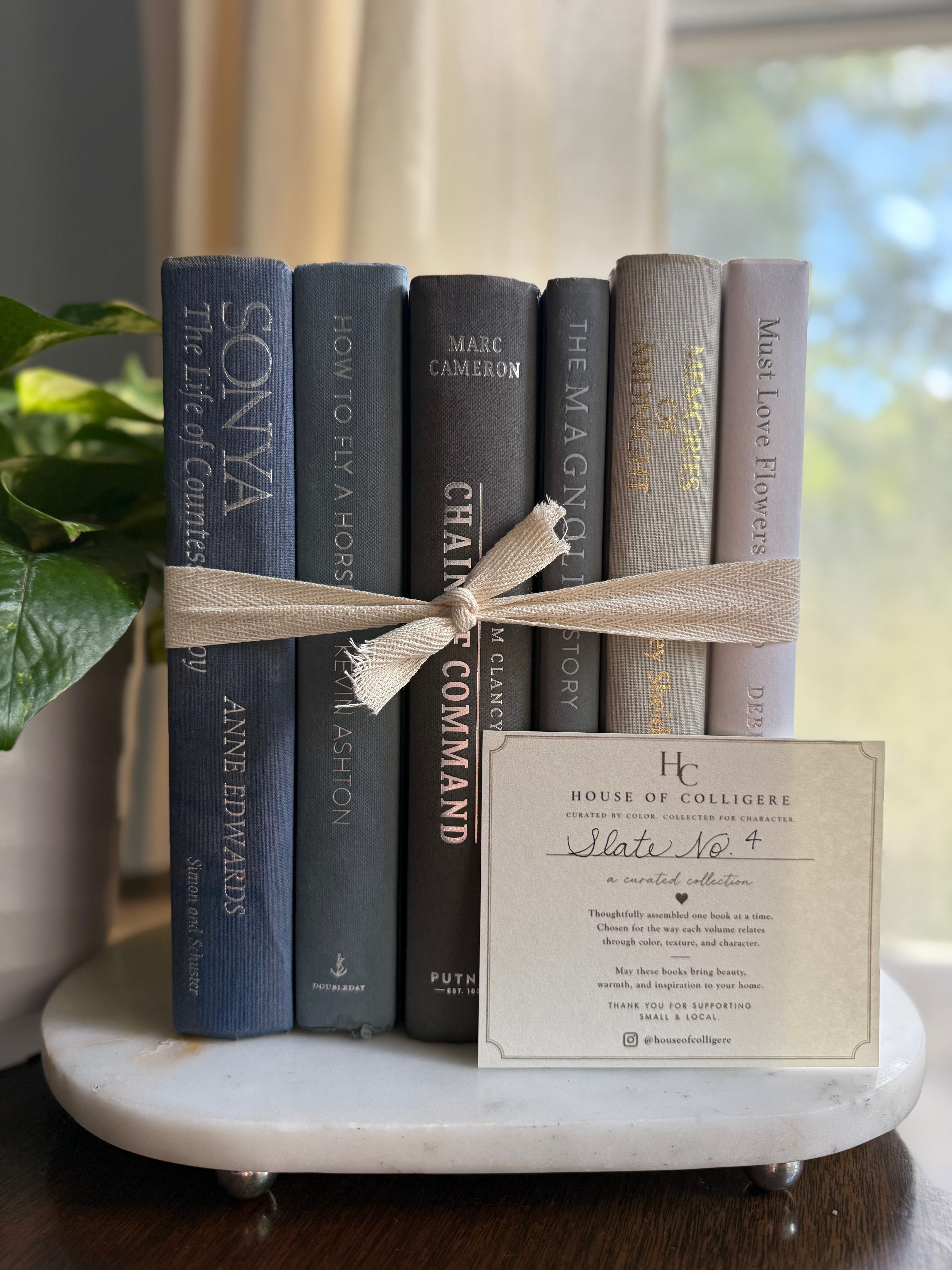 Curated collection of muted blue-gray, slate, charcoal, and softly weathered neutral books.