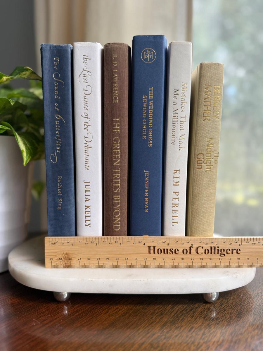 Curated collection of weathered blue, oyster, sand, linen, and driftwood-toned books with soft coastal character.