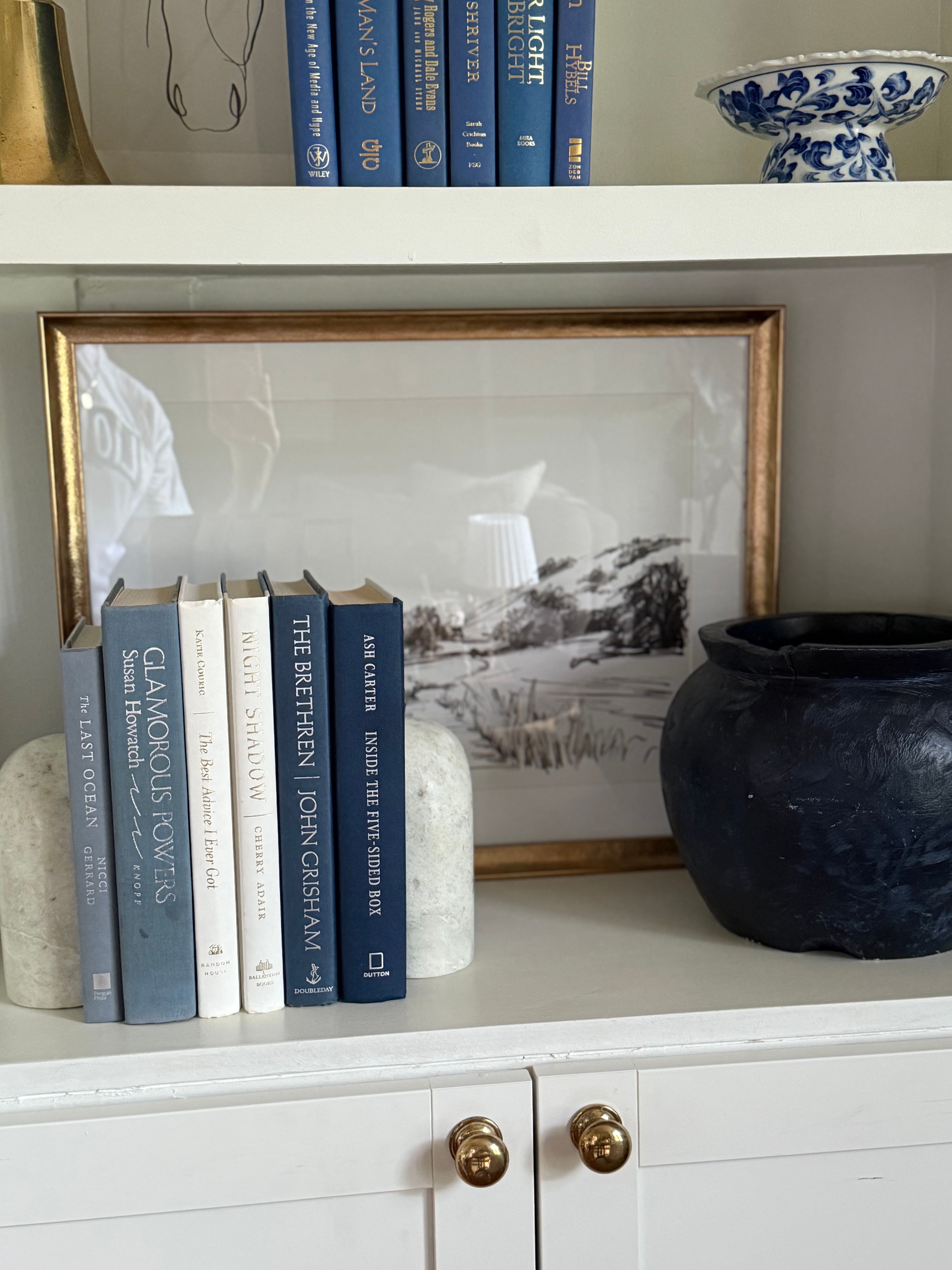 Curated collection of layered blue books ranging from pale coastal blue to deeper ocean tones.
