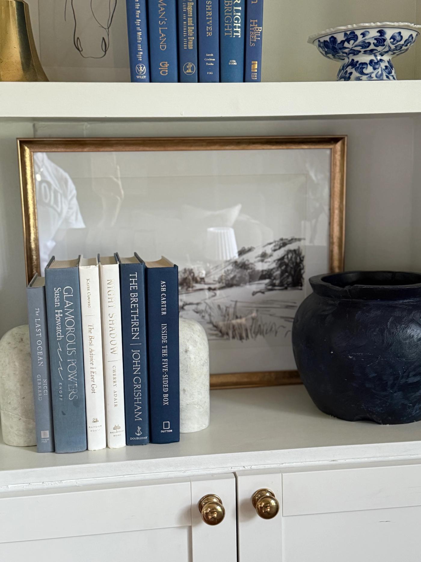 Curated collection of layered blue books ranging from pale coastal blue to deeper ocean tones.