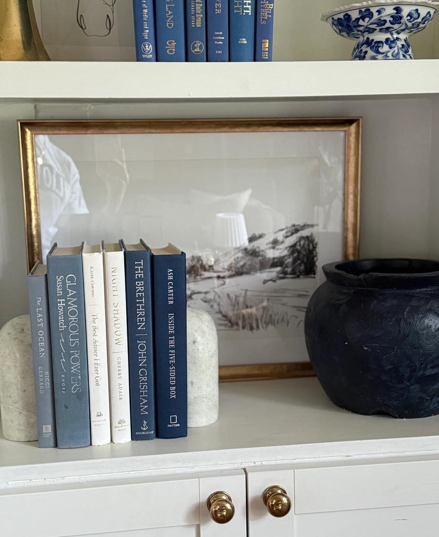 Curated collection of layered blue books ranging from pale coastal blue to deeper ocean tones.