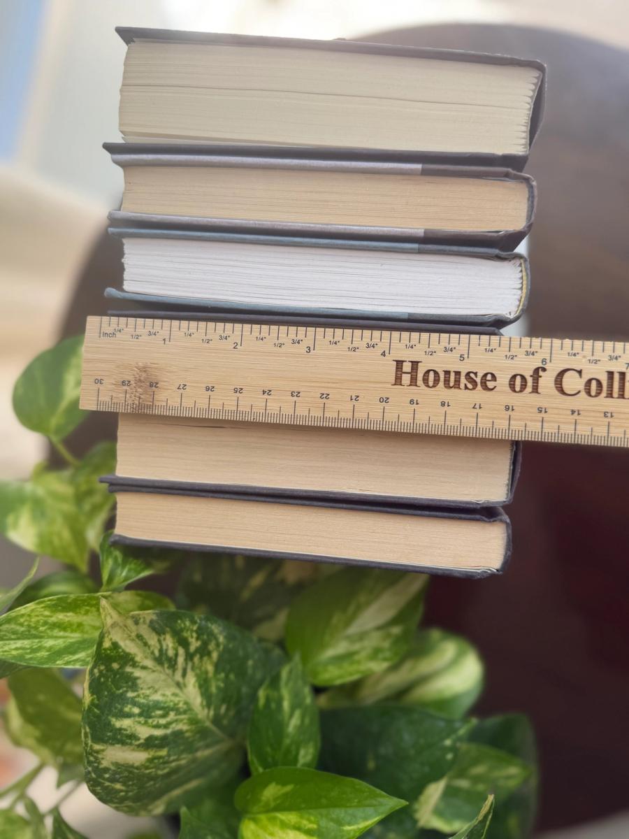 Curated collection of rich charcoal and black books with warm gold lettering and dramatic tonal depth.