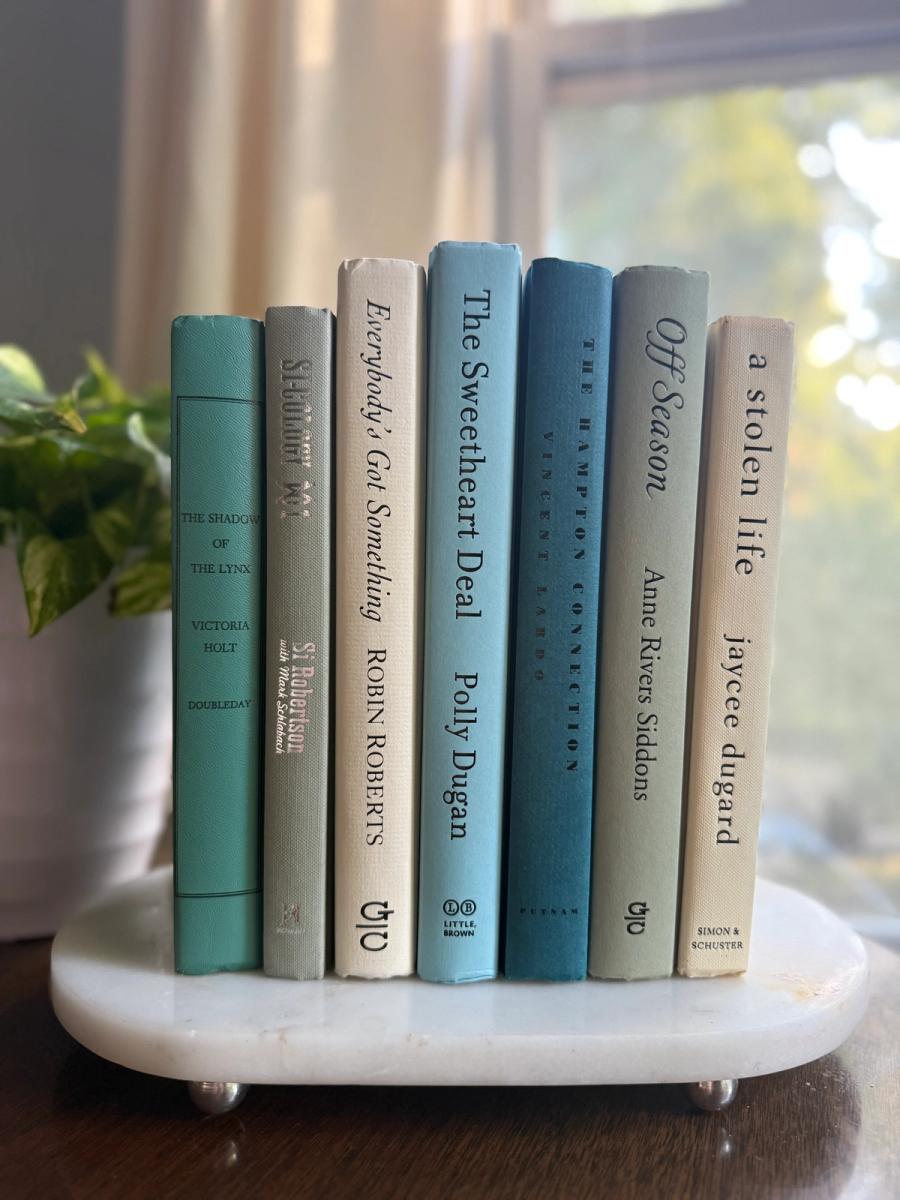 Curated collection of white, pale blue, sand, and soft coastal-neutral books with an airy, sun-faded look.