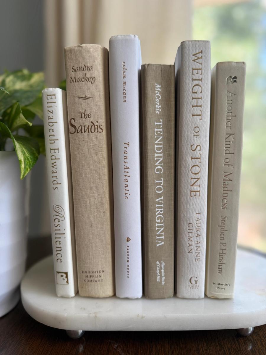 Linen book collection in cream and ivory tones, styled with a neutral ribbon on a marble pedestal