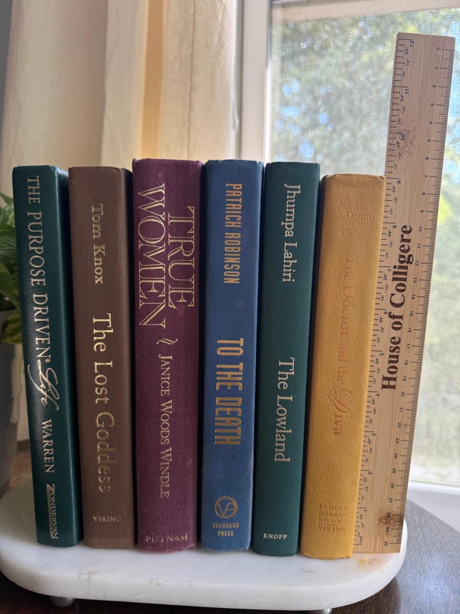 Curated collection of rich brown, hunter green, deep navy, and warm ivory books with classic gold accents.