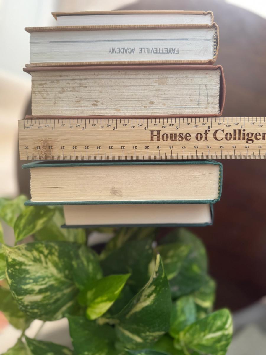 Curated collection of rich brown, hunter green, deep navy, and warm ivory books with classic gold accents.
