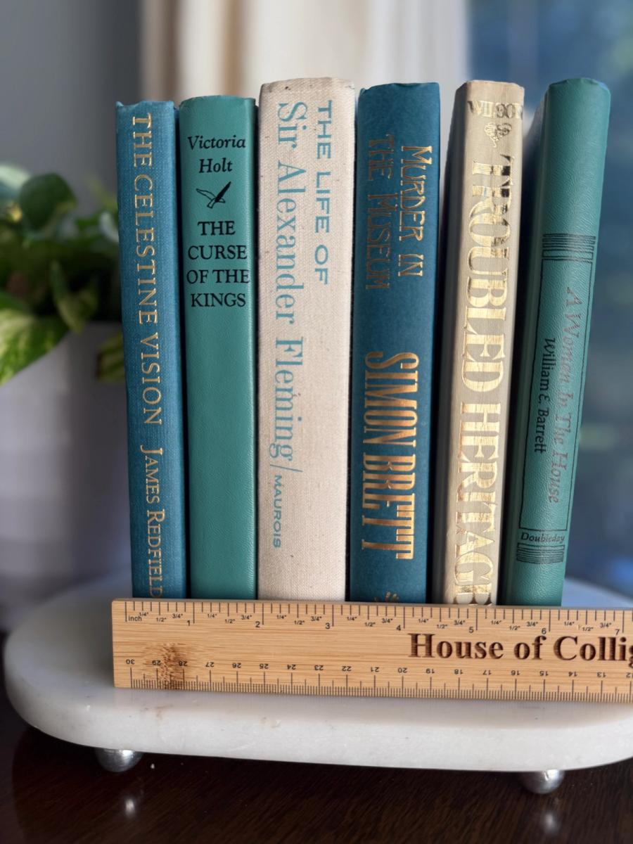 Curated collection of white, pale blue, sand, and soft coastal-neutral books with an airy, sun-faded look.