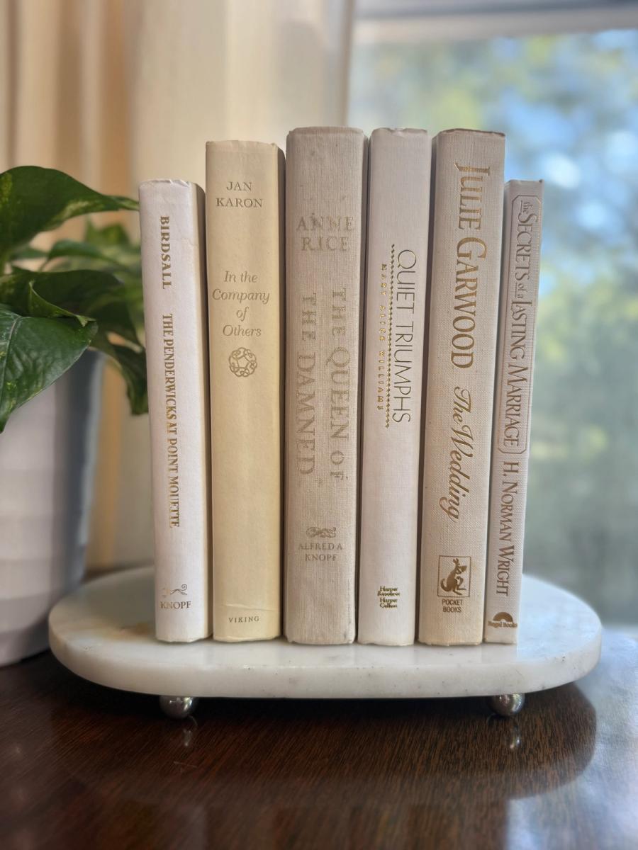 Curated collection of crisp white, ivory, and warm cream books with soft neutral tones.