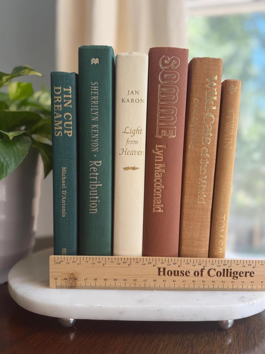 Curated collection of rich brown, hunter green, deep navy, and warm ivory books with classic gold accents.