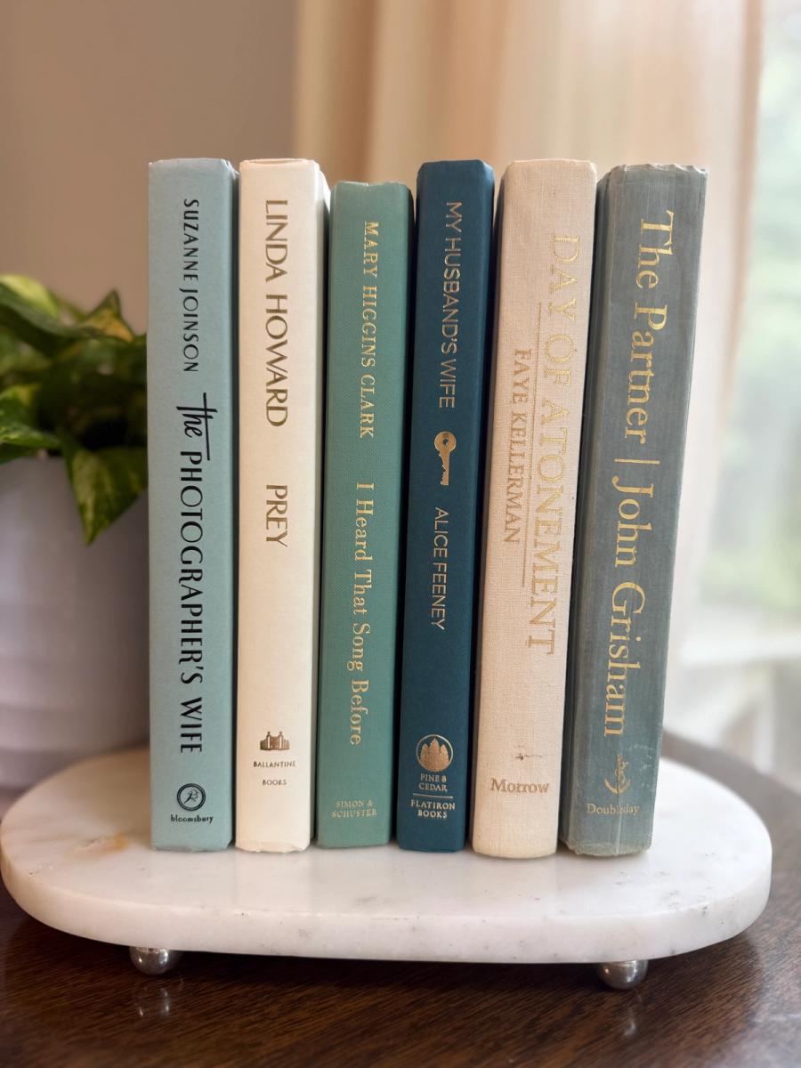 Curated collection of white, pale blue, sand, and soft coastal-neutral books with an airy, sun-faded look.