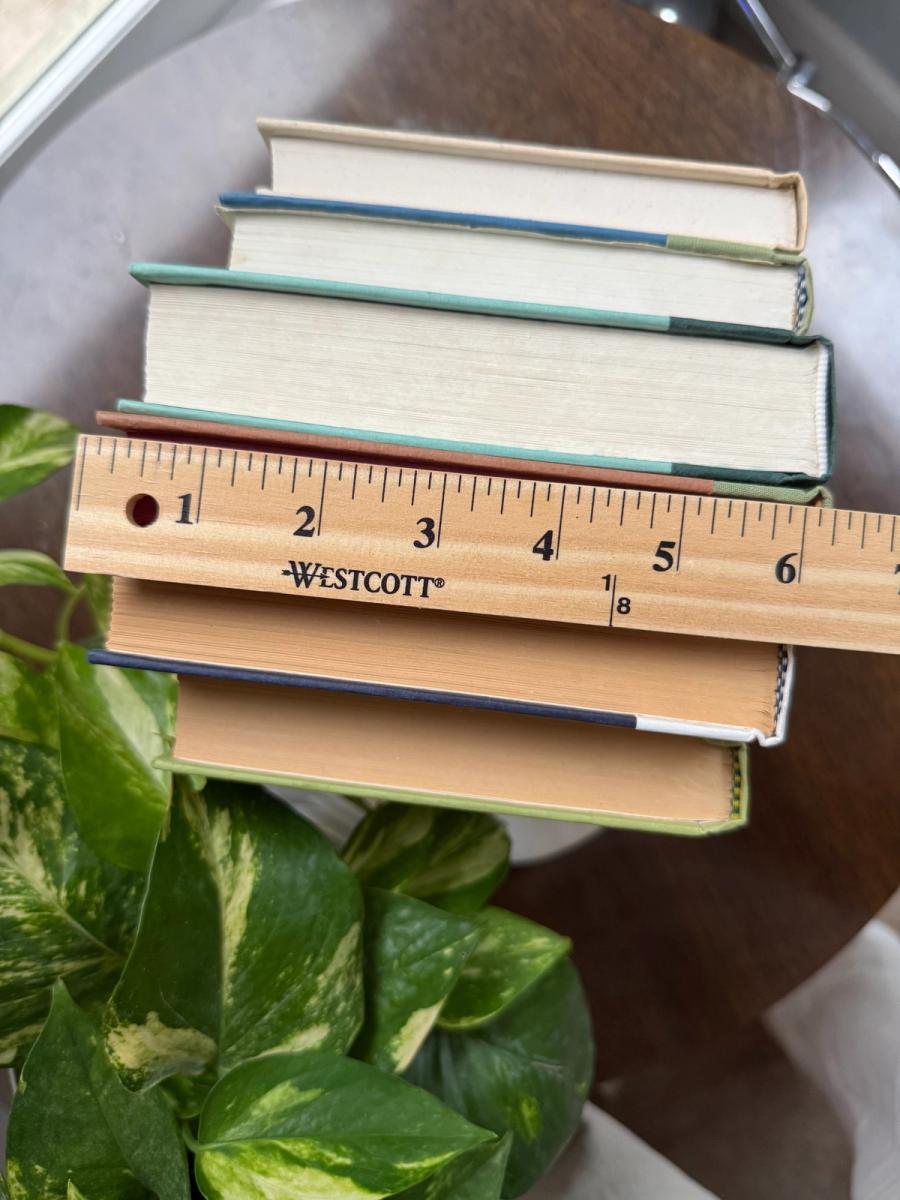 Curated collection of soft sage, olive, cream, and muted green books with botanical tones.