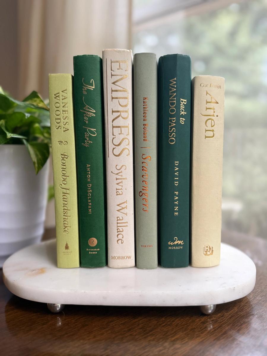 Curated collection of soft sage, olive, cream, and muted green books with botanical tones.