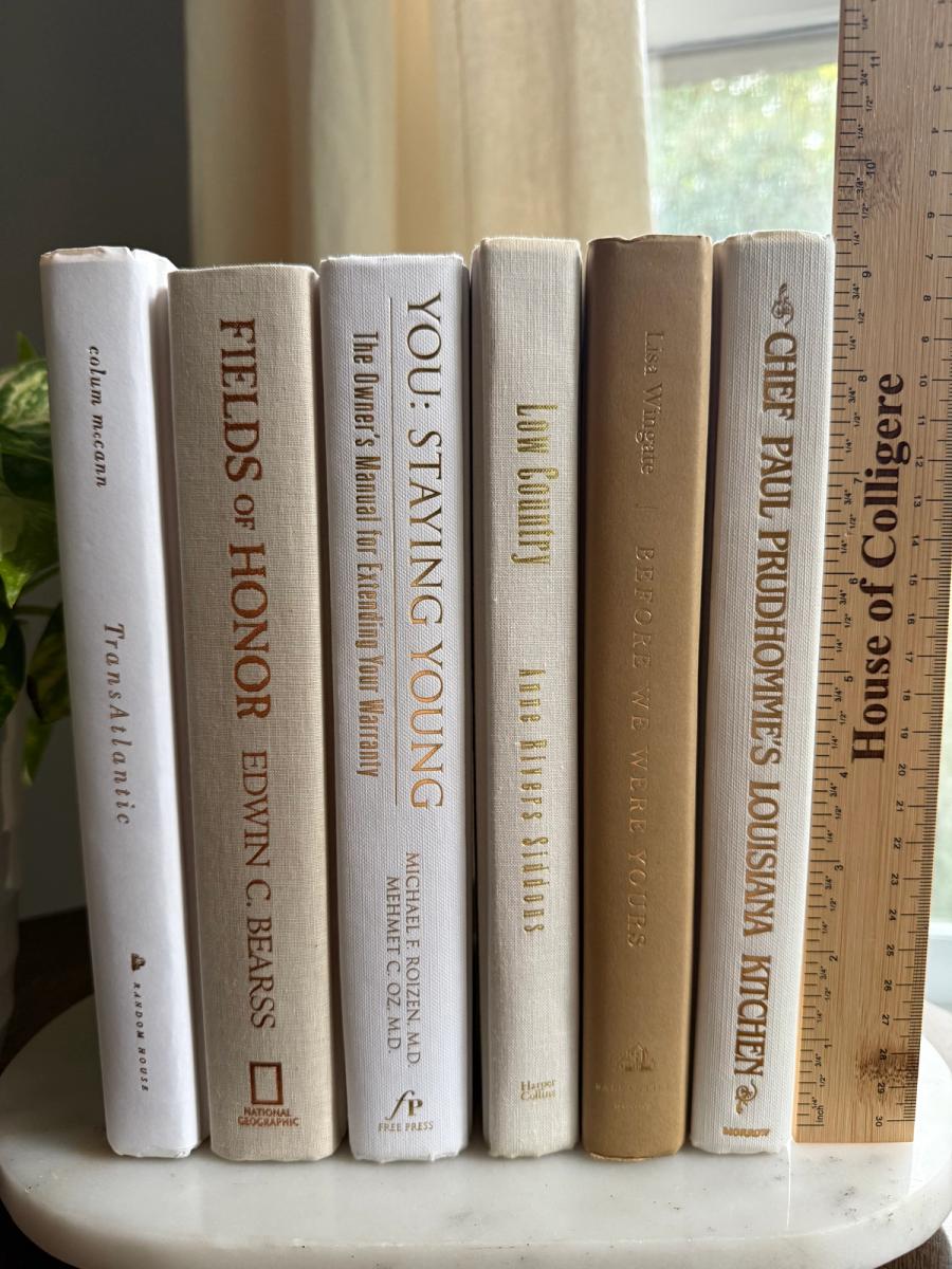 Curated collection of crisp white, ivory, and warm cream books with soft neutral tones.