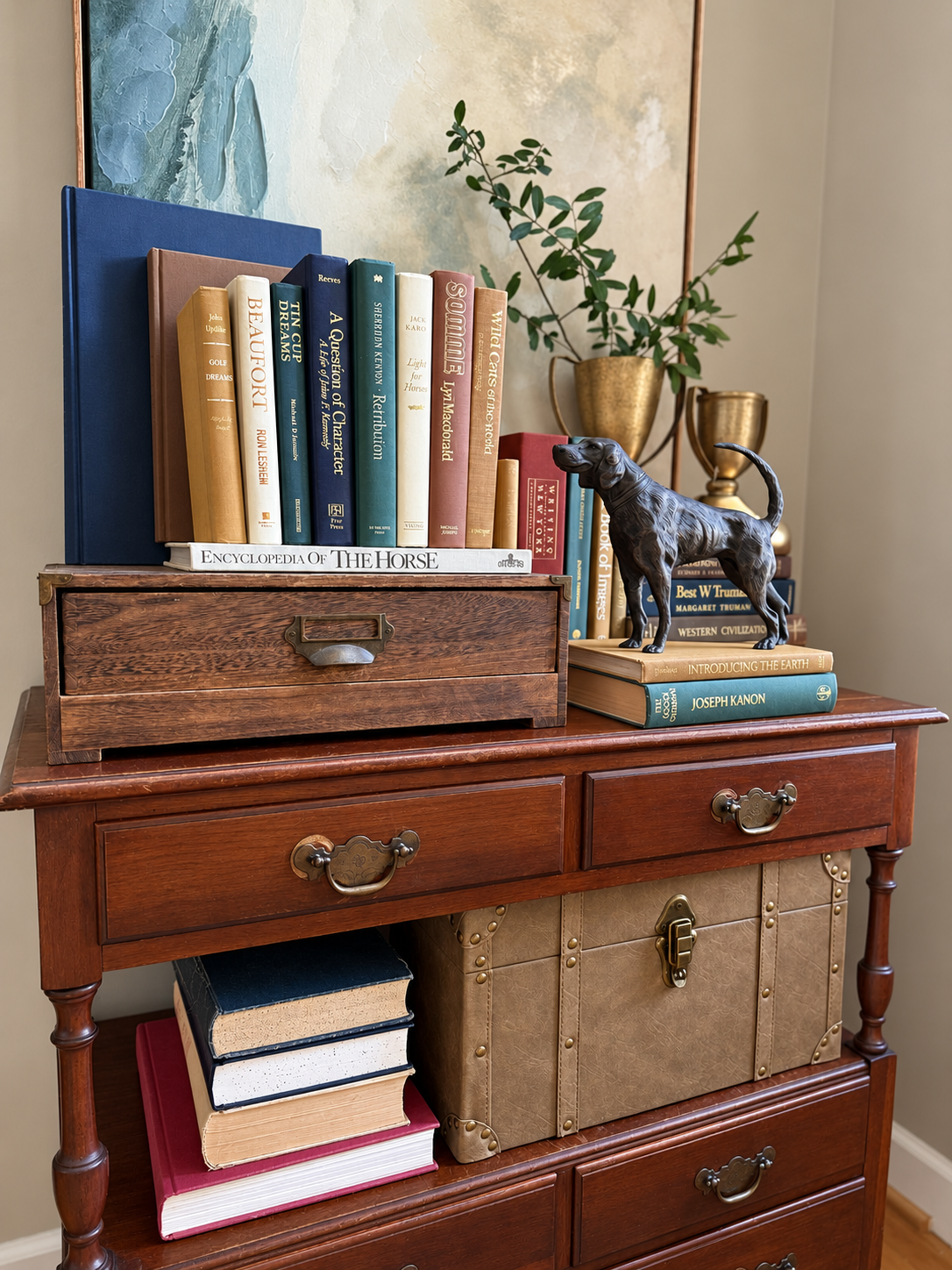 Curated collection of rich brown, hunter green, deep navy, and warm ivory books with classic gold accents.