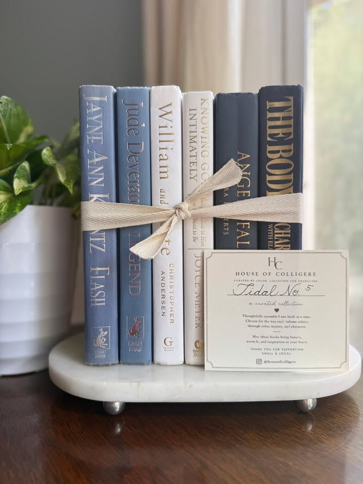 Curated collection of layered blue books ranging from pale coastal blue to deeper ocean tones.