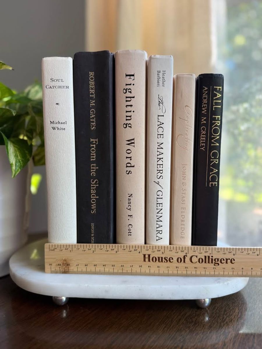 Curated collection of parchment, cream, warm beige, and black books with soft neutral contrast and classic detailing.