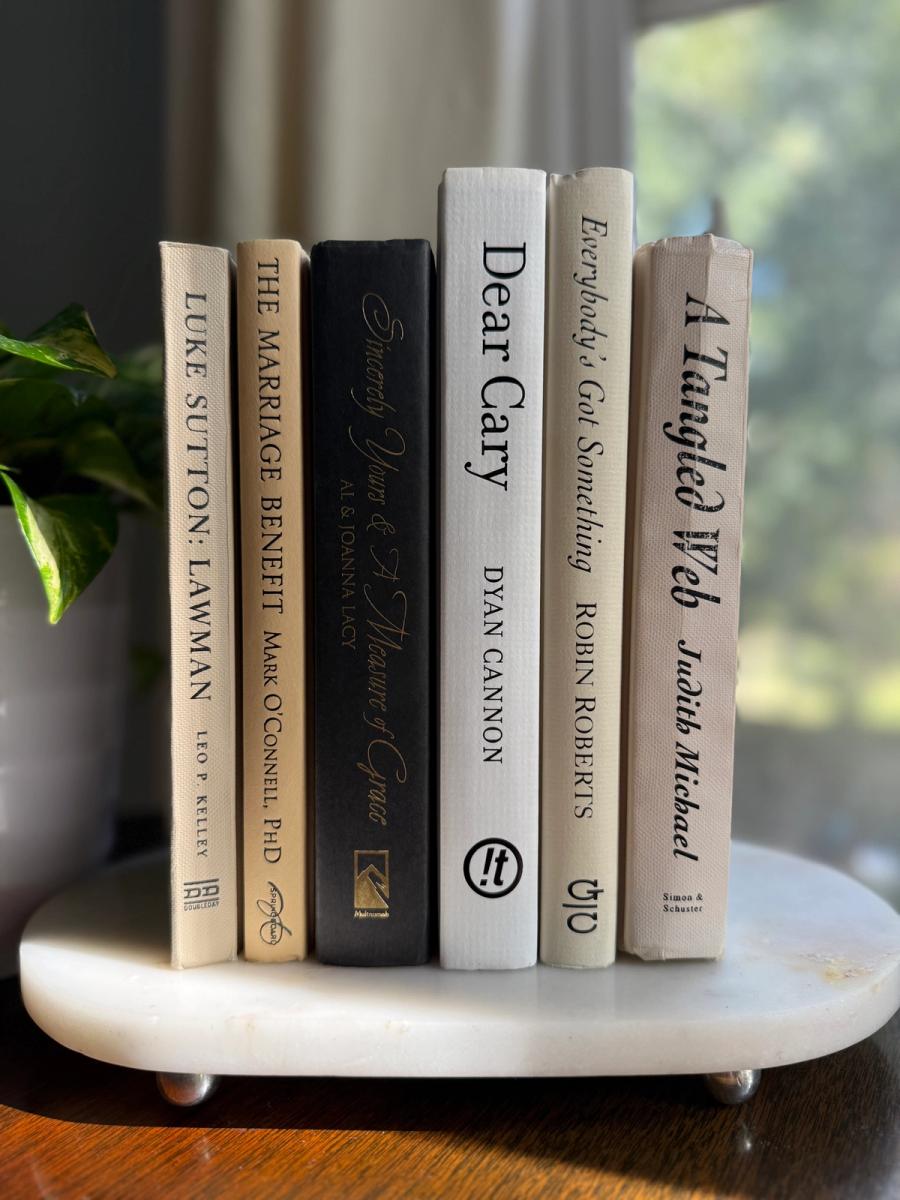 Curated collection of parchment, cream, warm beige, and black books with soft neutral contrast and classic detailing.