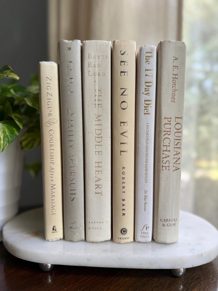 Curated collection of crisp white, ivory, and warm cream books with soft neutral tones.