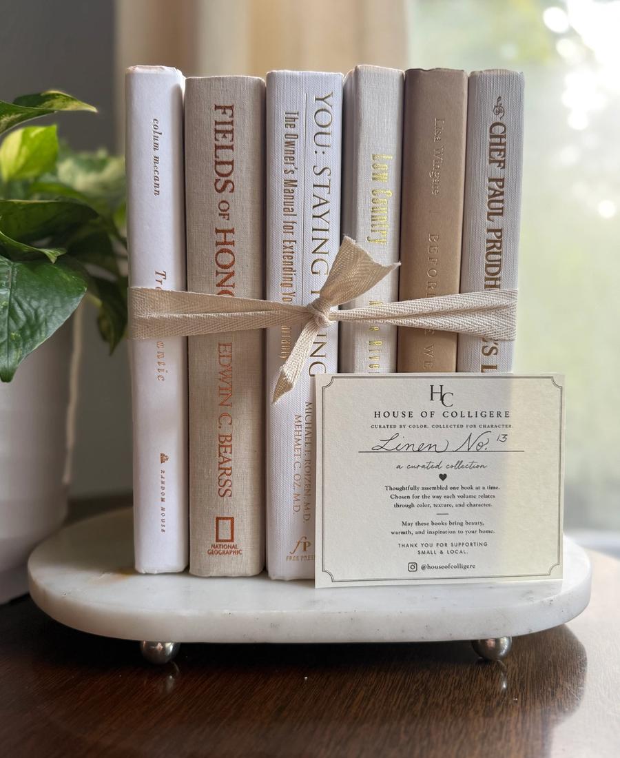 Curated collection of crisp white, ivory, and warm cream books with soft neutral tones.