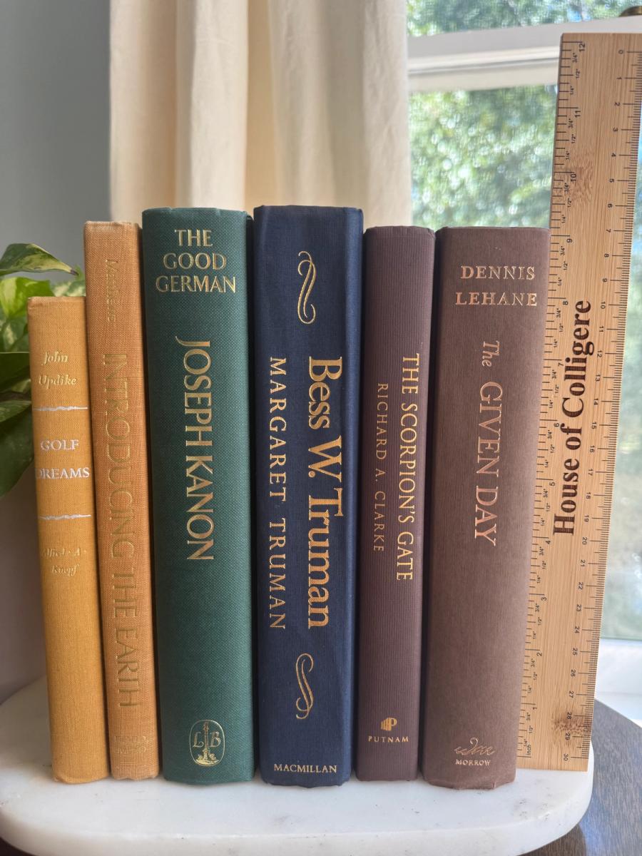 Curated collection of rich brown, hunter green, deep navy, and warm ivory books with classic gold accents.