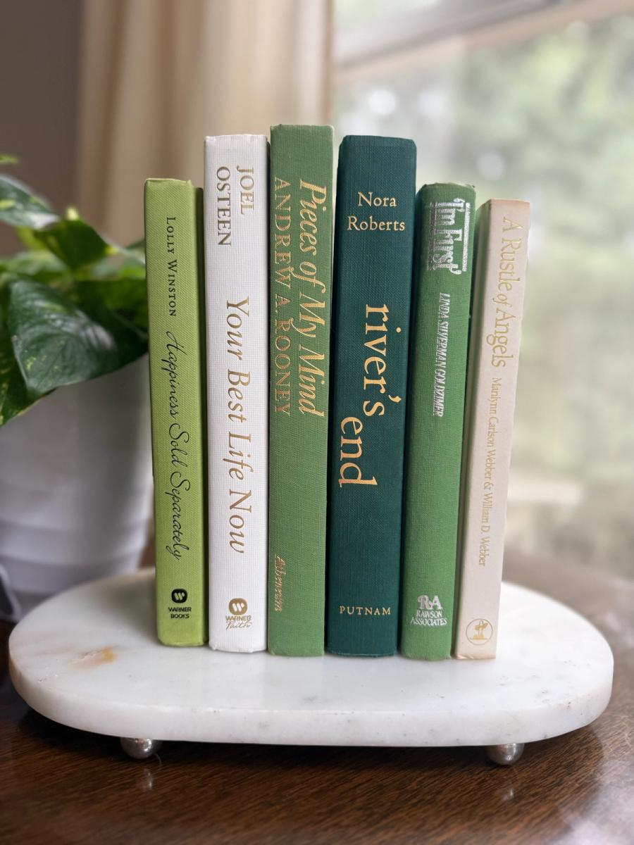 Curated collection of soft sage, olive, cream, and muted green books with botanical tones.