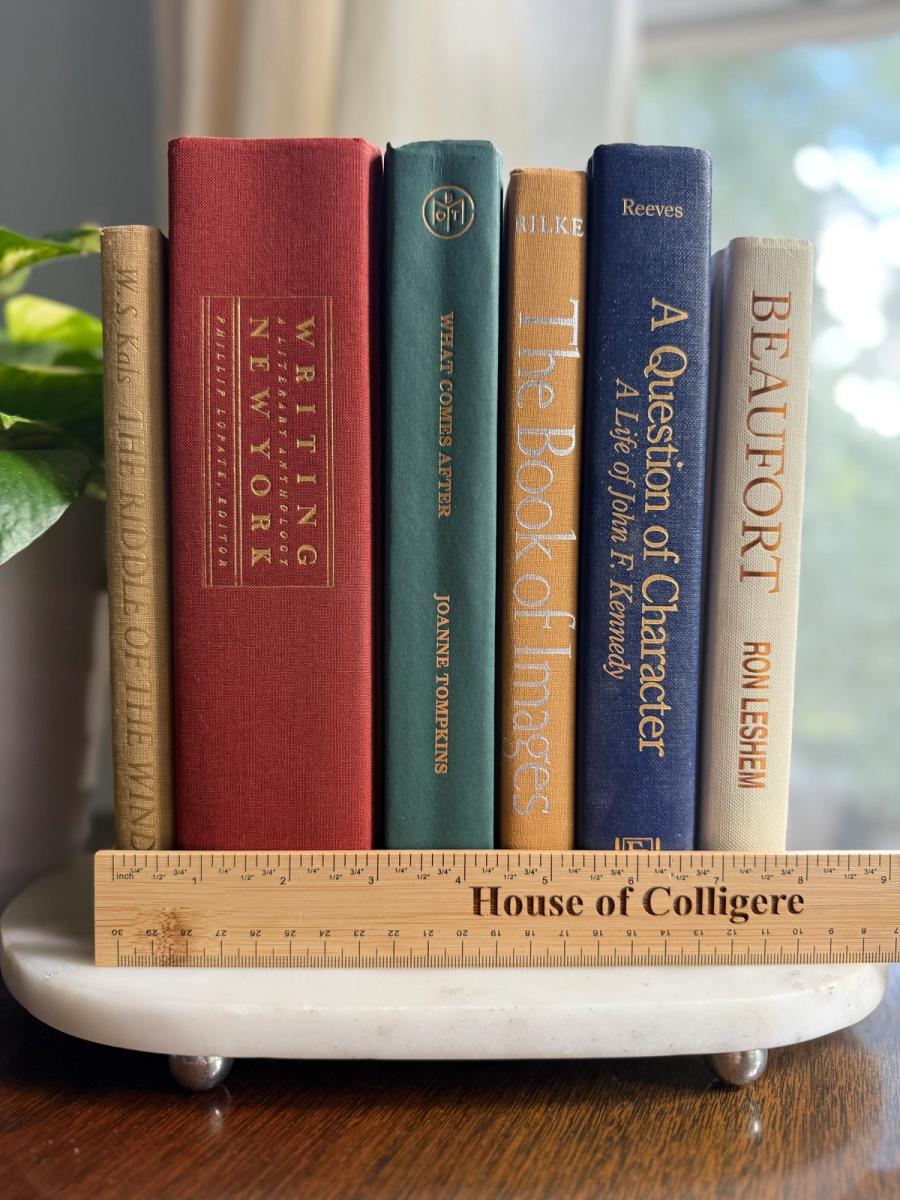 Curated collection of rich brown, hunter green, deep navy, and warm ivory books with classic gold accents.