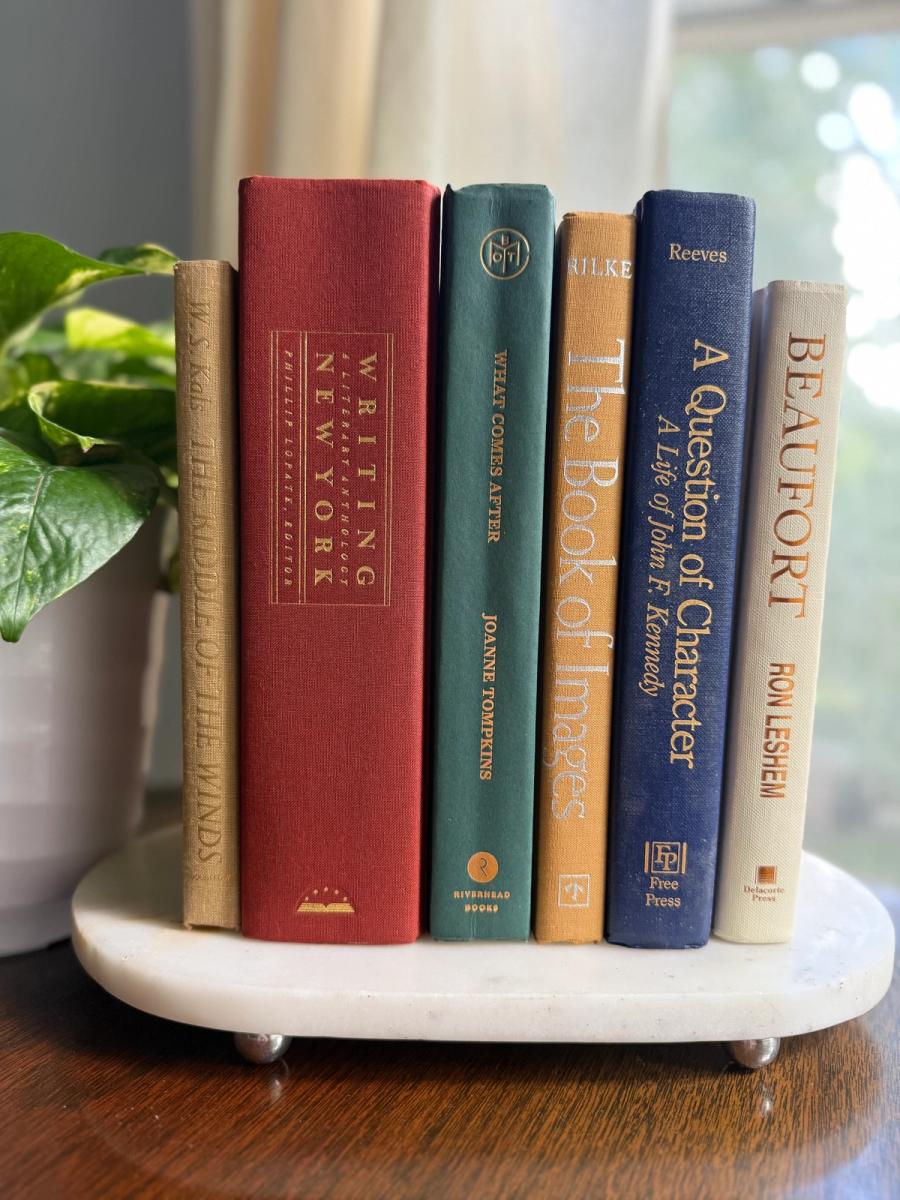 Curated collection of rich brown, hunter green, deep navy, and warm ivory books with classic gold accents.