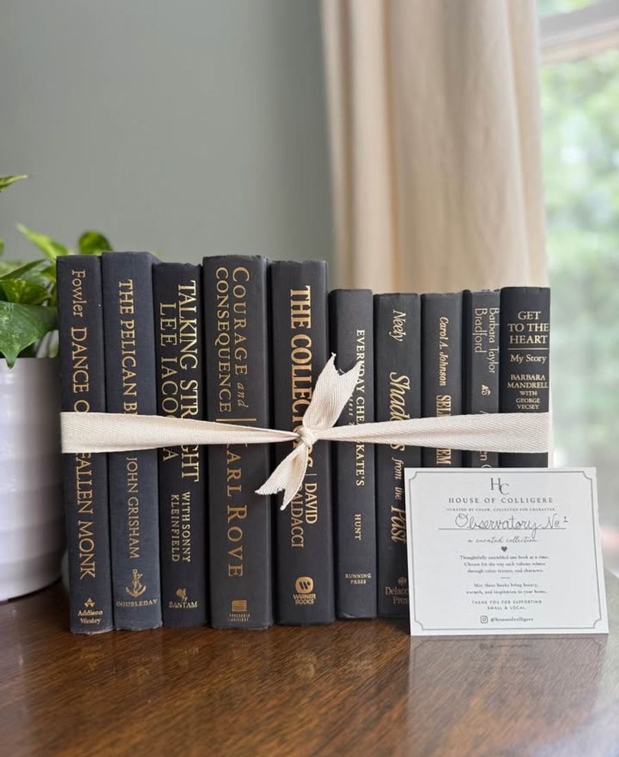 A collection of 10 hardcover books in rich charcoal and black cloth bindings with warm gold lettering.