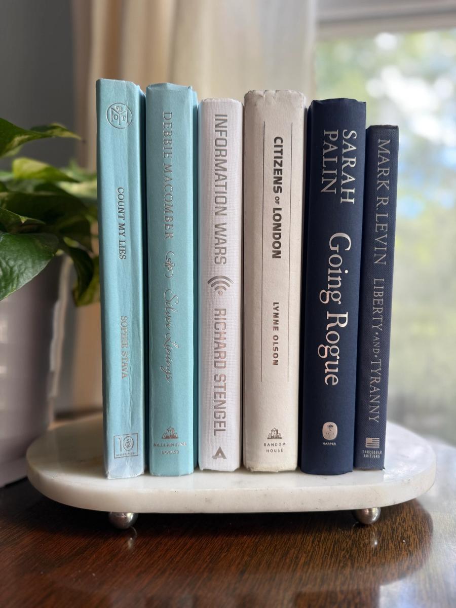 Curated collection of layered blue books ranging from pale coastal blue to deeper ocean tones.