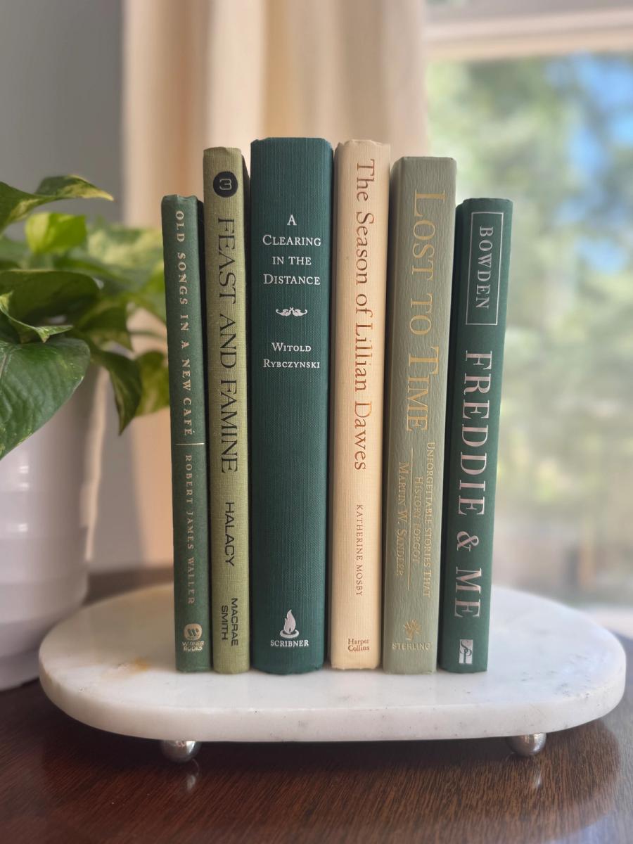 Curated collection of soft sage, olive, cream, and muted green books with botanical tones.
